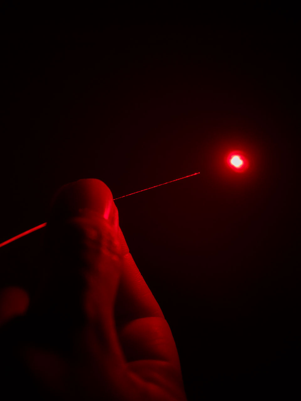 Una persona sostiene un cable de fibra óptica iluminado en color rojo